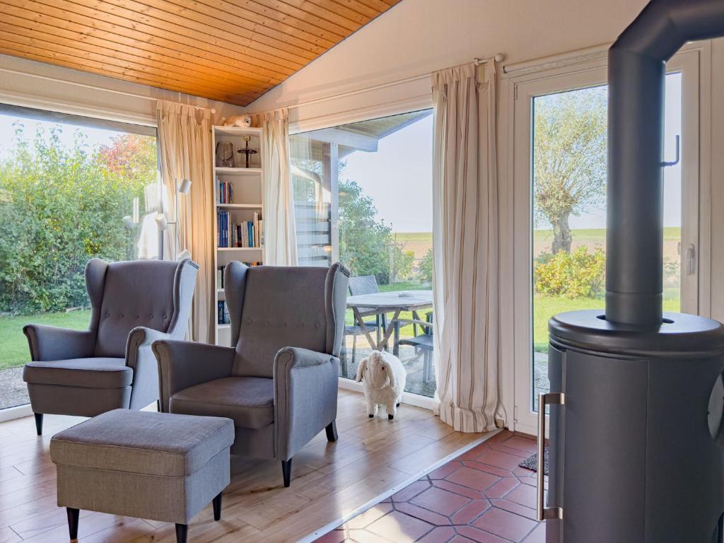 a living room with a wood stove with chairs and a table at Lundenbergsand in Simonsberg