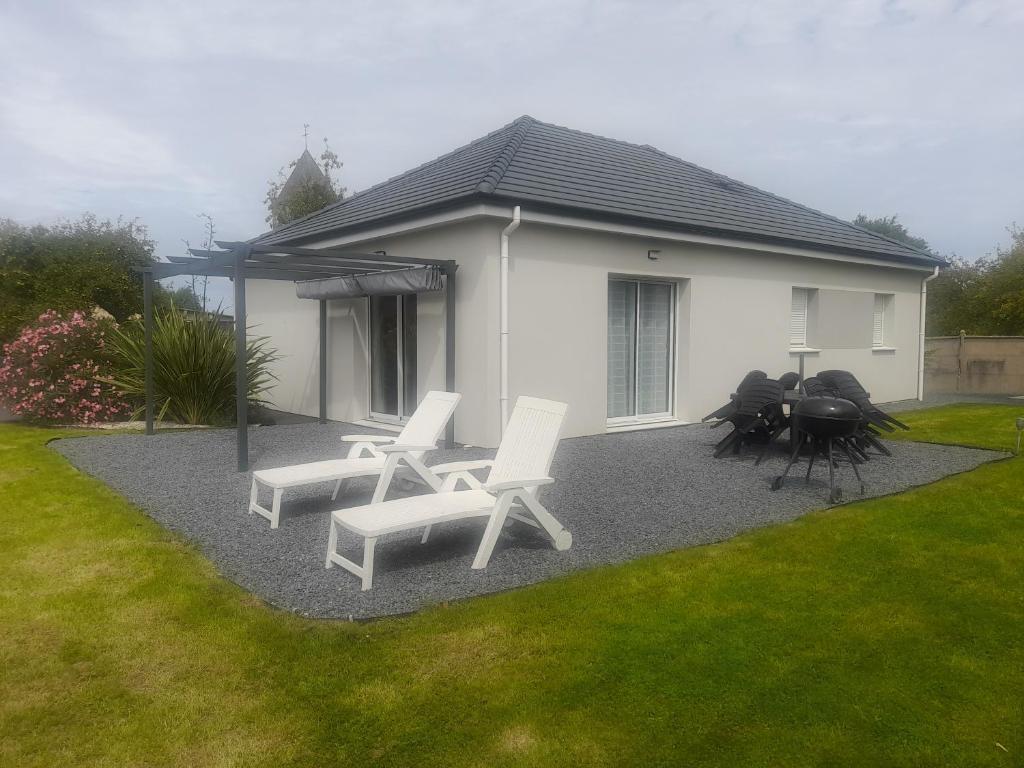 een patio met witte stoelen en een huis bij Casa Sierra -Etretat in Sainte-Marie-au-Bosc