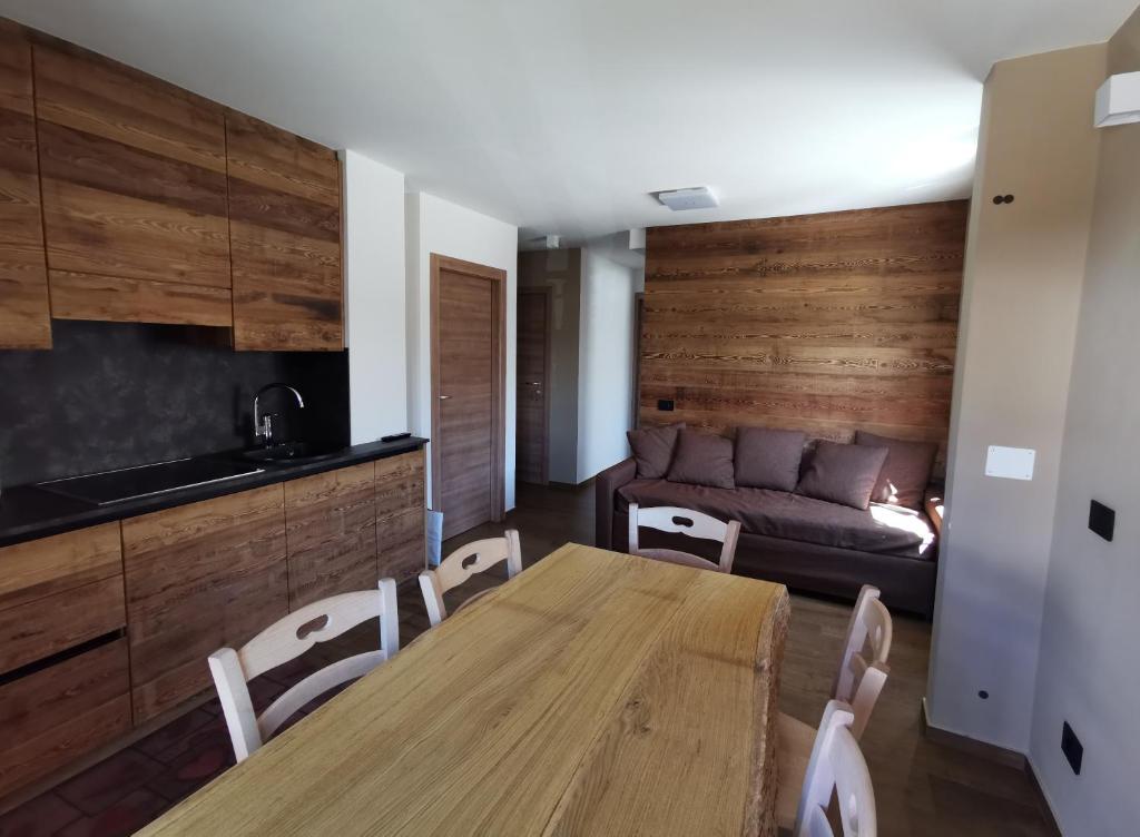 a dining room with a table and a couch at La Stua Livigno in Livigno
