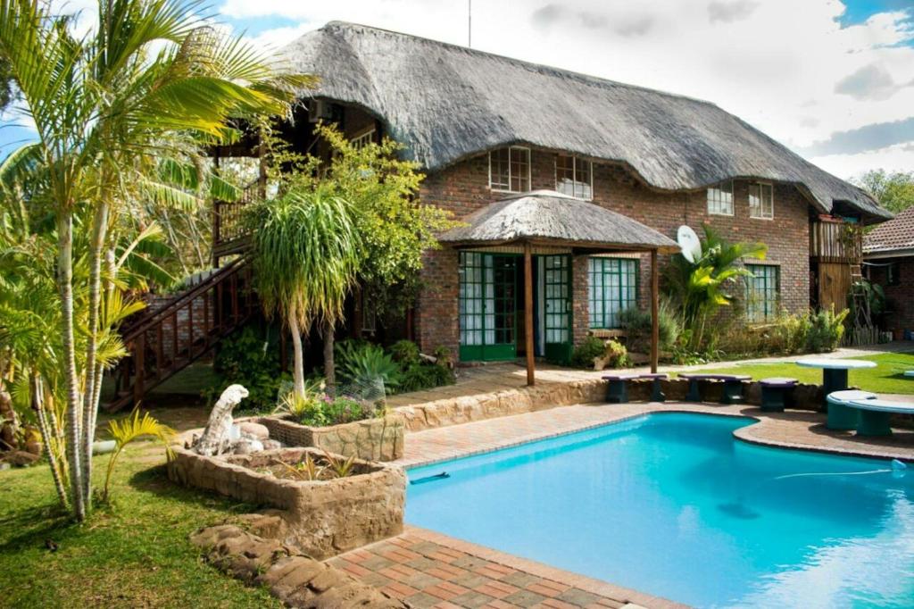 a house with a swimming pool in front of it at Do Drop In in Hoedspruit
