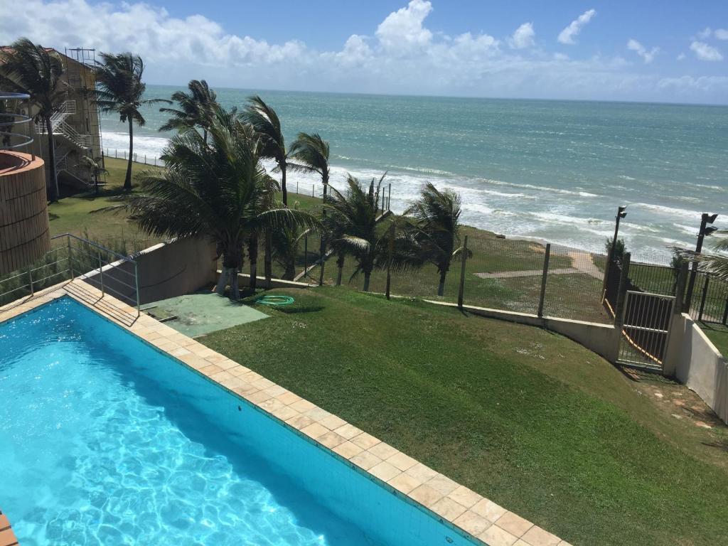 een zwembad met uitzicht op de oceaan bij Costeira Praia - Belo Flat in Natal