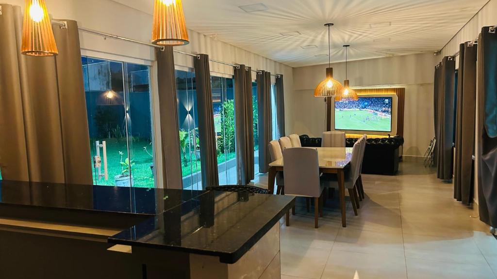 a dining room with a table and a television at Pousada Ventos in Chapada dos Guimarães