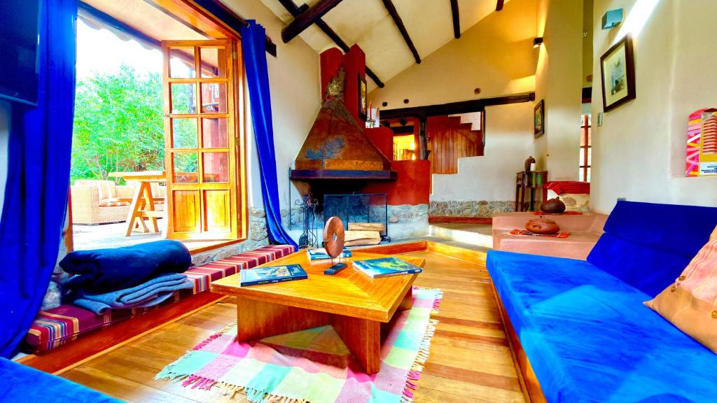 a living room with a blue couch and a table at Casa Munay in Urubamba