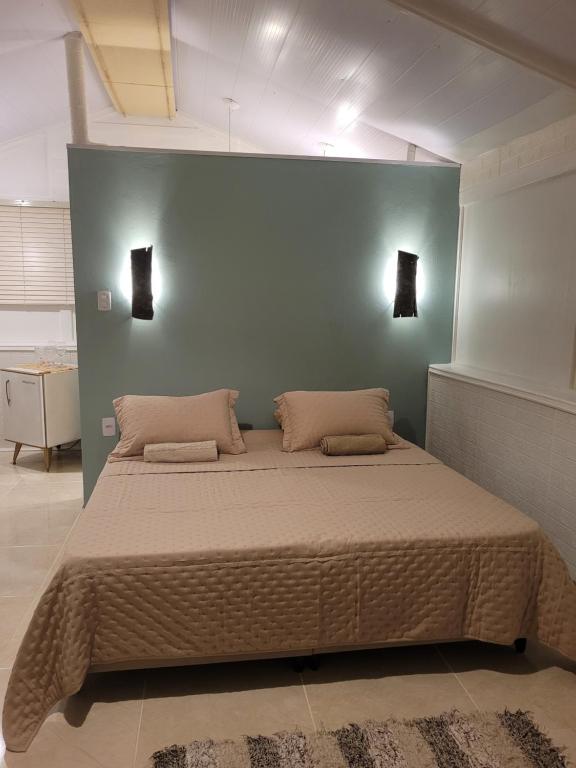a bedroom with a large bed with two pillows at Suíte Cambucá in Praia do Bananal