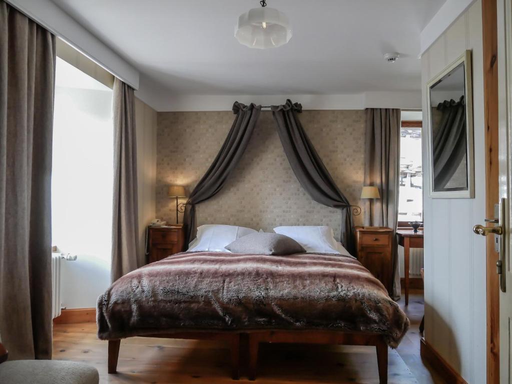 een slaapkamer met een groot bed met een baldakijn bij Hôtel Bella Tola & SPA in Saint-Luc