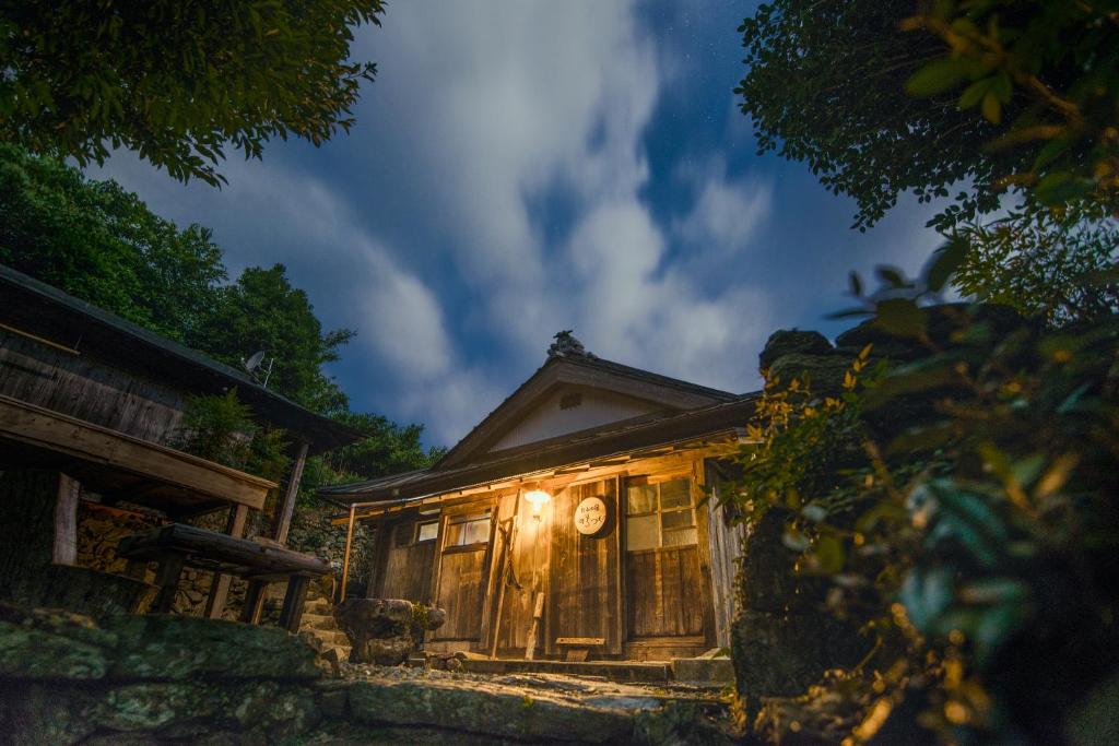 una piccola casa con luci sulla parte anteriore di Oyamanoyado Michitsuji a Otoyocho