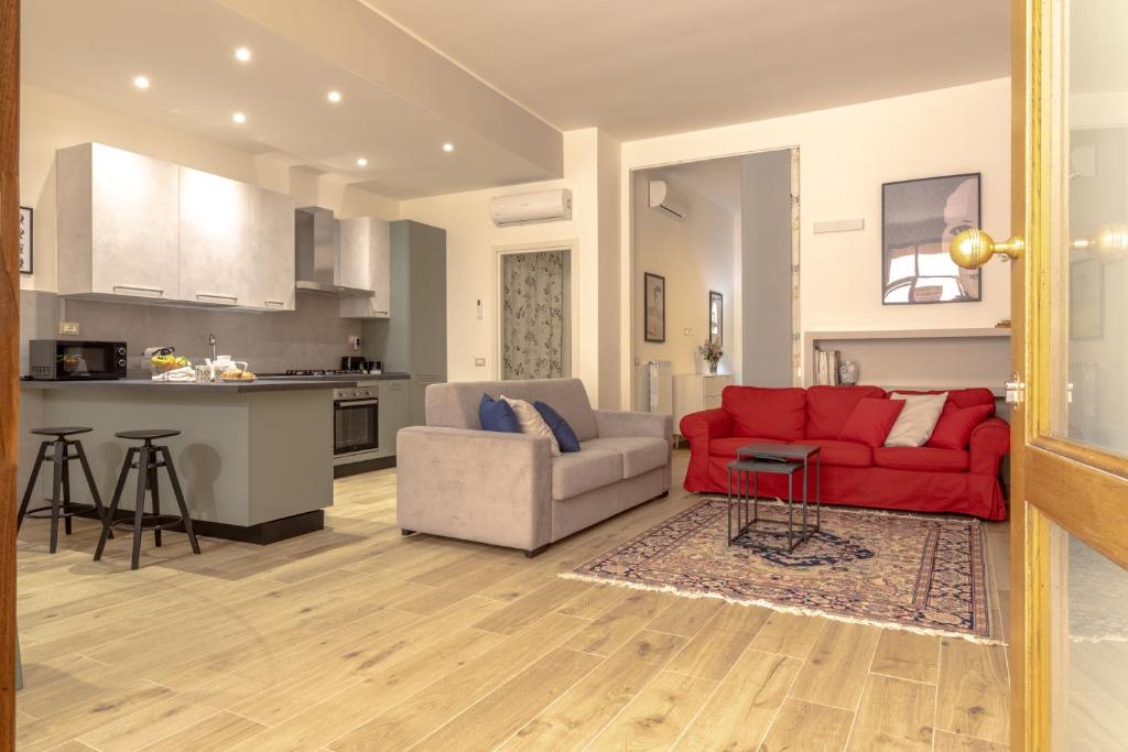 ein Wohnzimmer mit einem roten Sofa und einer Küche in der Unterkunft Loft Altobelli in Rieti
