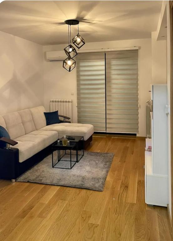 a living room with a couch and a table at Apartman Hilandarska in Lukavica