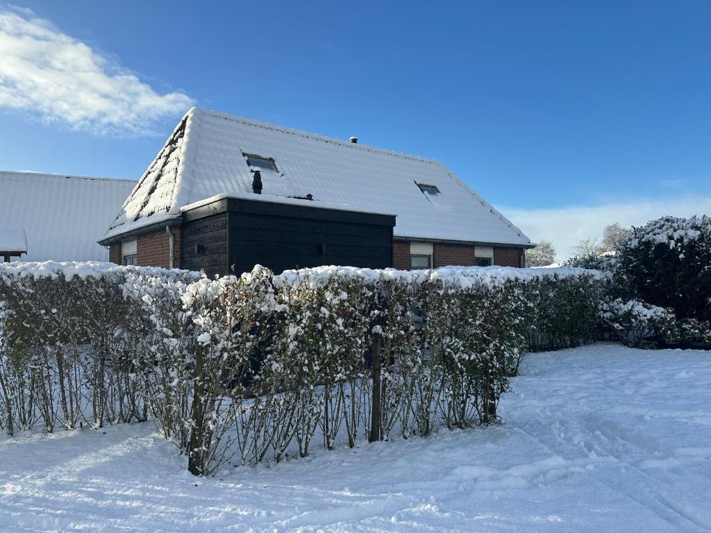 una casa con una recinzione nella neve di Landelijk Hijken a Hijken