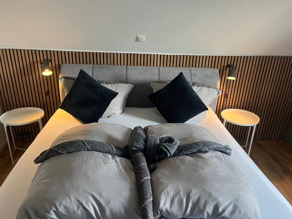 een slaapkamer met een bed met 2 kussens en 2 tafels bij Wurmbergblick Ferienwohnung in Braunlage