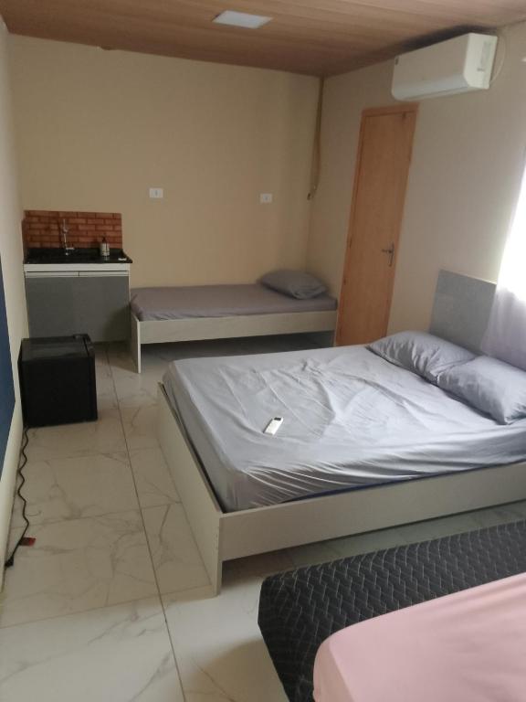 a bedroom with two beds and a bench in it at EL Shaday in Guarujá
