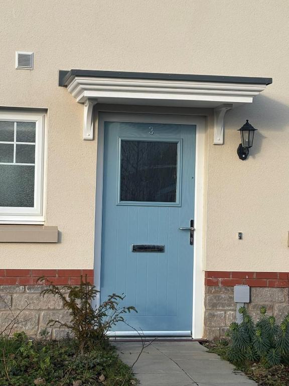 a blue door on a house with a window at 3,Lime Tree Ave in Haverfordwest