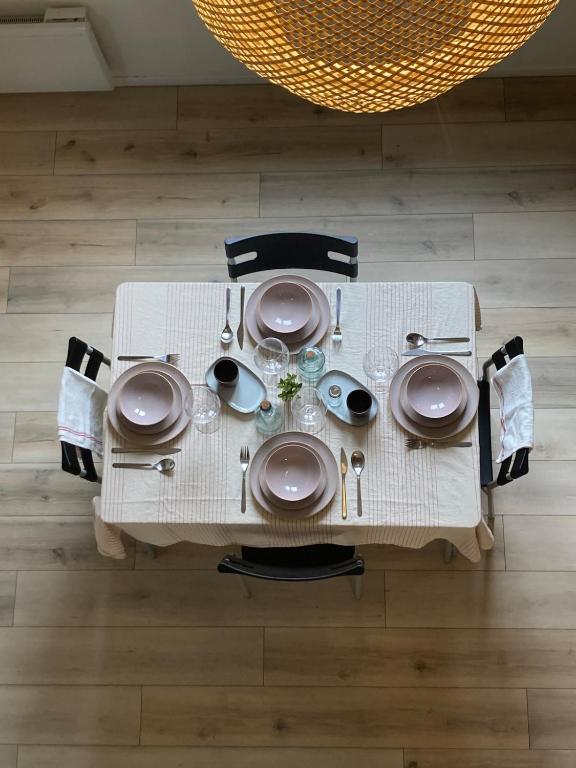 a table with plates and utensils on it at Oniris - Parenthèse urbaine in Mont-de-Marsan