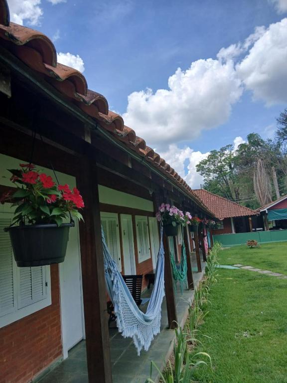 a hammock hanging from the side of a house at Pousada Casa de Campo in Conservatória