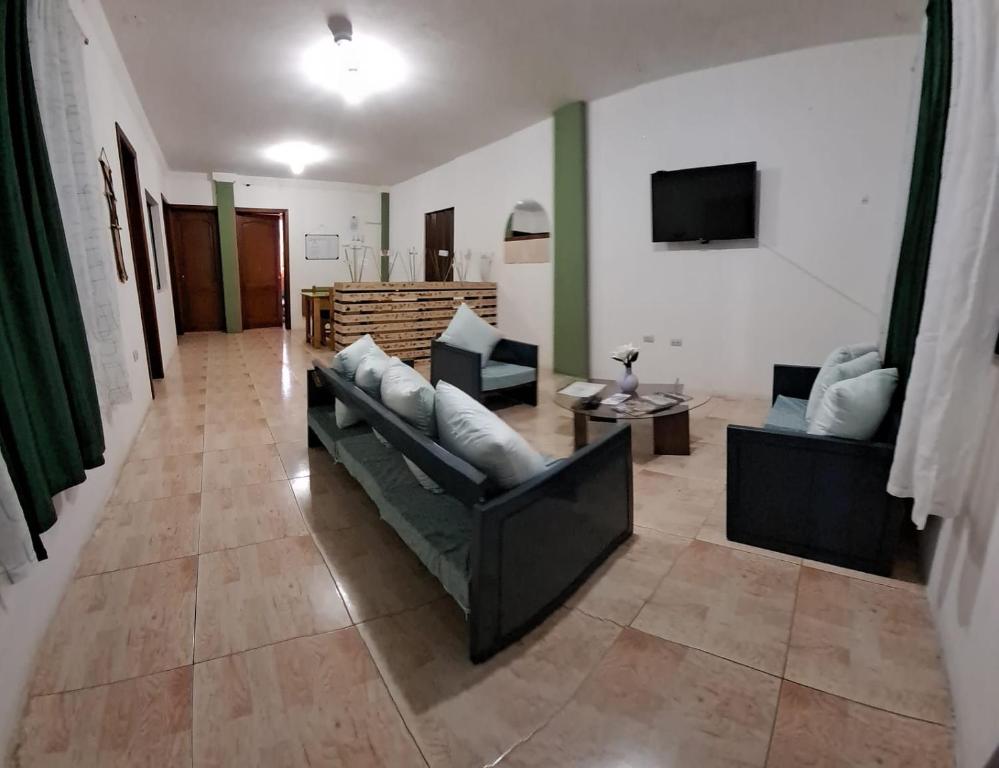 un soggiorno con due divani e una televisione di Cómodo y acogedor departamento familiar, cerca del casco histórico a Gualaceo