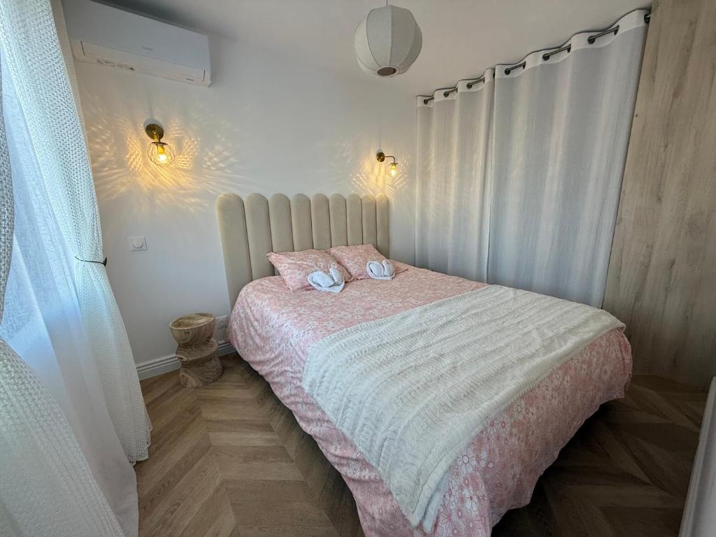 een slaapkamer met een bed met twee kussens erop bij Cocon Idéal familles & couples à 10 min Disneyland avec lit Queen size & parking privé in Coupvray