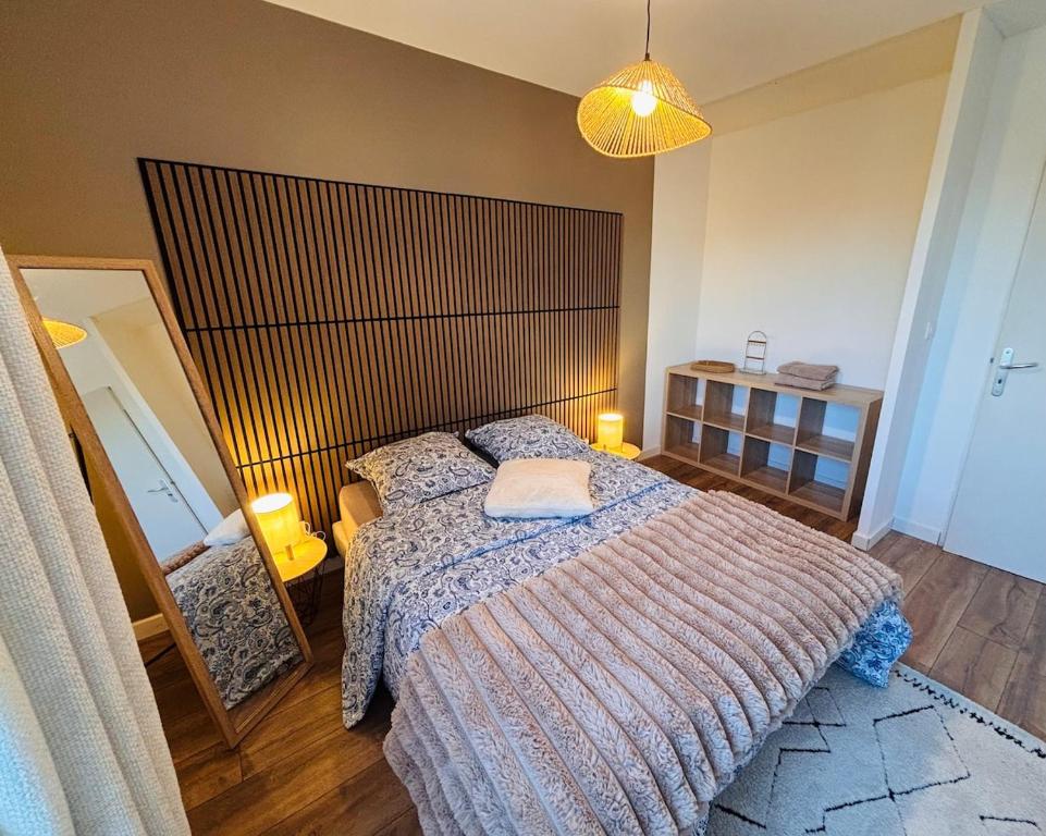 a bedroom with a large bed with a large headboard at L'appartement du Château in Pfastatt