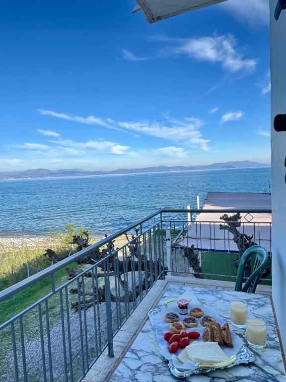 a table with food on a balcony overlooking the ocean at Cherronisi Apartments in Áyios Andréas