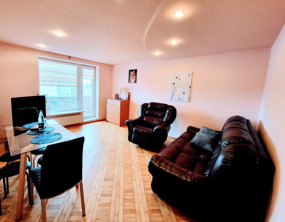 un soggiorno con un divano in pelle e un tavolo di SPACIOUS Apartment in the SUN CITY a Šiauliai