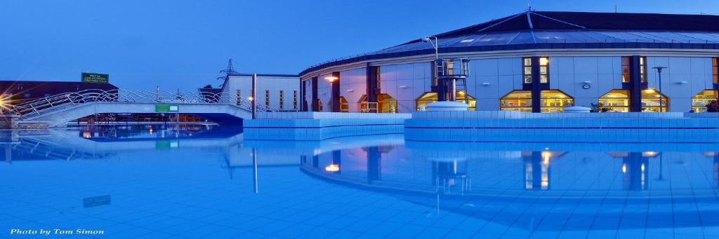 un edificio con una piscina d'acqua di fronte di Termál Apartman a Tiszaújváros