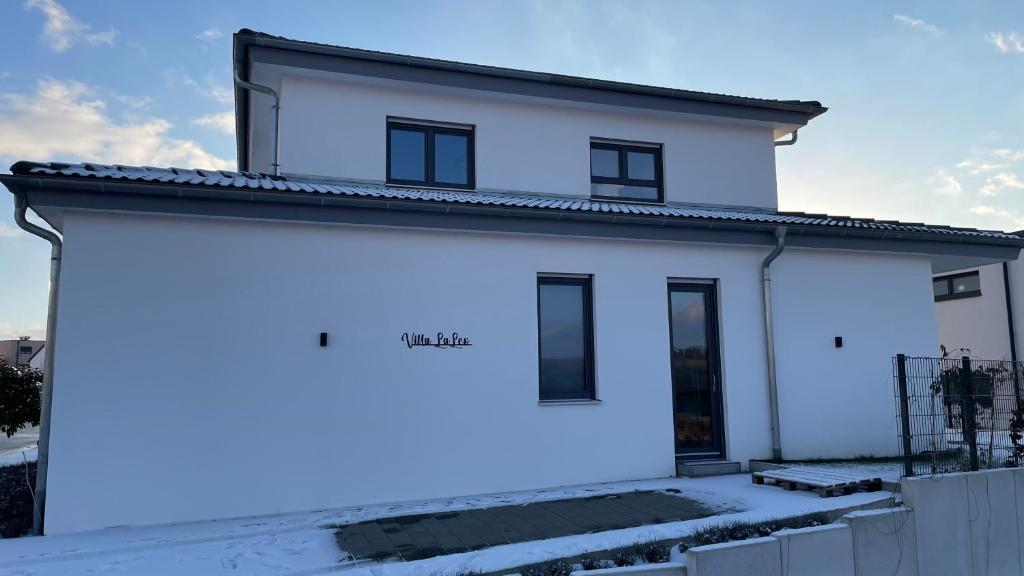 a white house is lit up in the snow at Villa LaLeo in Künzelsau