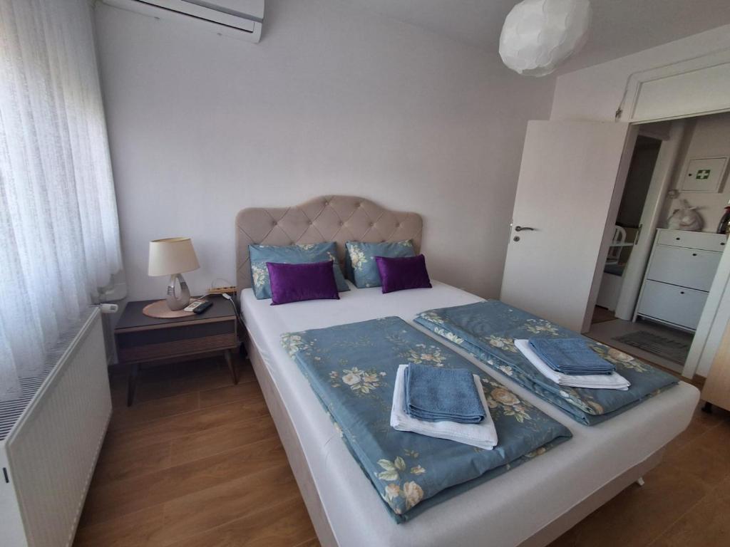 een slaapkamer met een groot bed met paarse kussens bij Esma 2 in Bihać