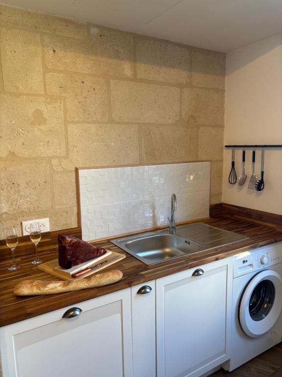 a kitchen counter with a sink and a dishwasher at Résidence ARTHUS Cinopé in Pierrefonds