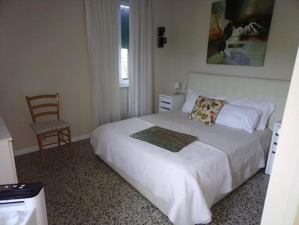 a bedroom with a bed with a chair and a window at casa del sole Ossuccio in Como