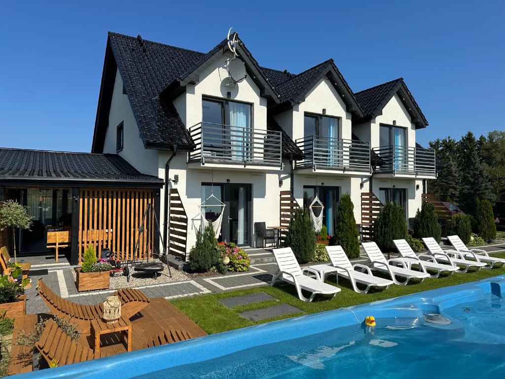a house with a swimming pool in front of it at Holiday Amber - in Niechorze