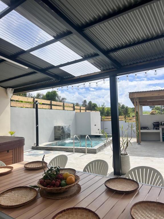 a wooden table with a bowl of fruit on it at Villa Canne & Ô in Saint-Joseph