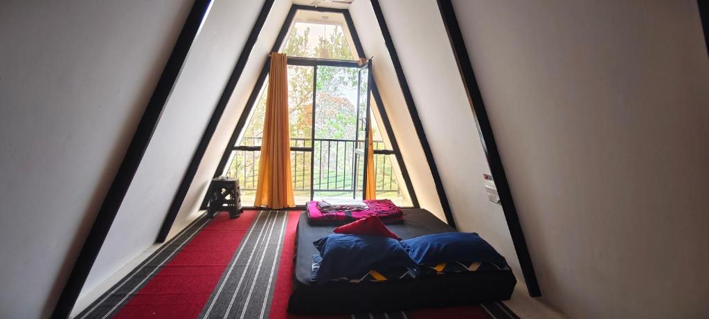 een kamer met een bed voor een raam bij Vagamon misty Hills Resort in Vagamon