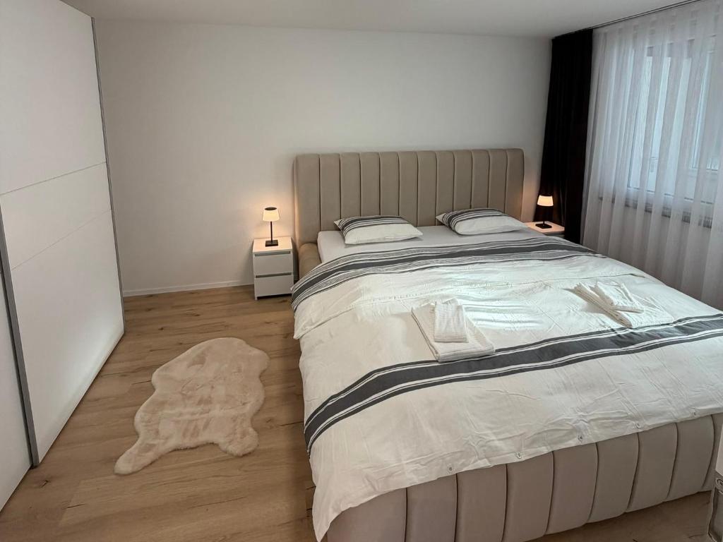 a bedroom with a large bed with a rug on the floor at Deine Auszeit mit Alpenblick in Kandergrund