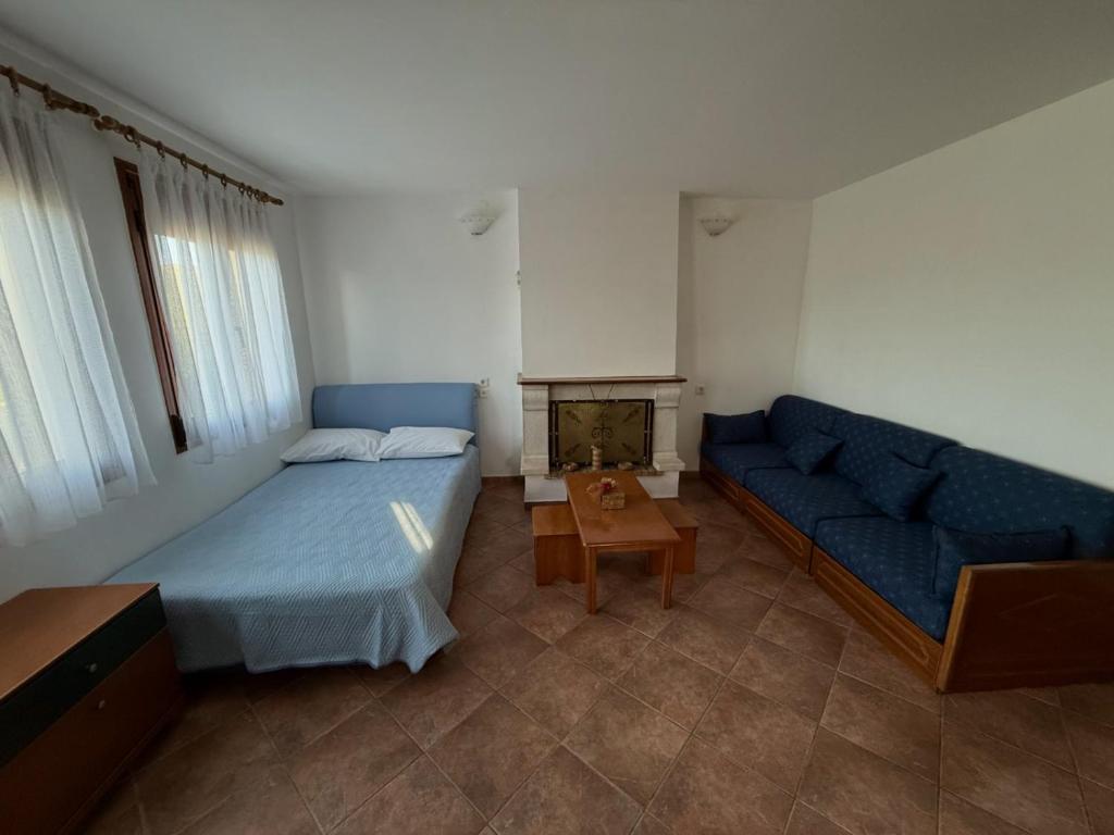 een slaapkamer met een blauw bed en een bank bij Arxontiko Manteio in Manteio
