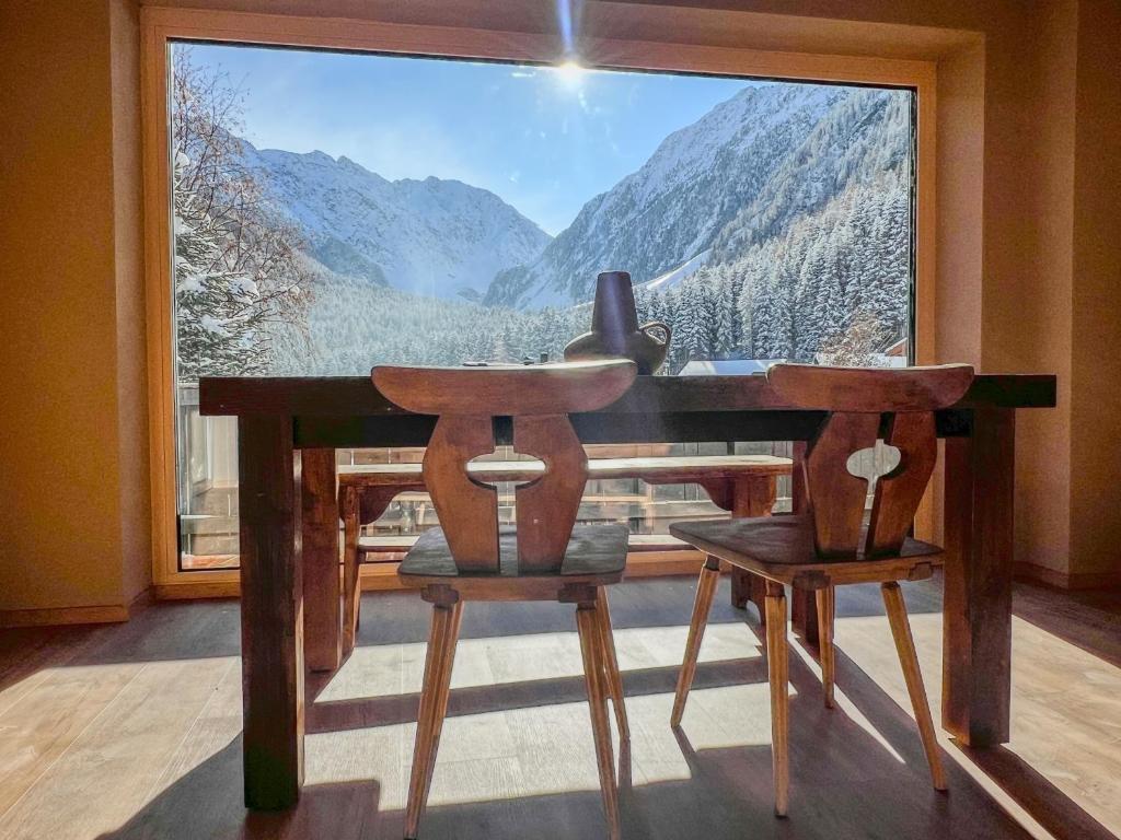 un tavolo e due sedie davanti a una finestra di Alpine Apartments St-Sigmund a Sankt Sigmund im Sellrain