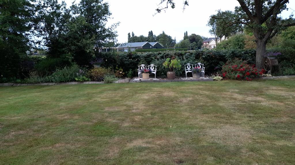 a yard with two lawn chairs in a yard at De Veldhoeve in Apeldoorn