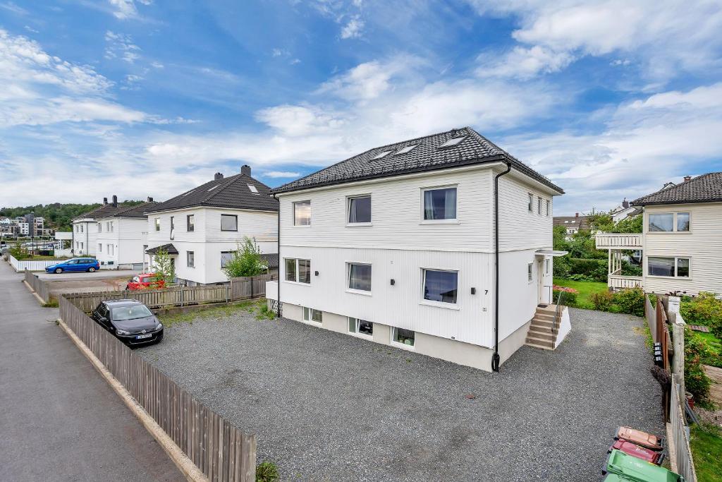 a white house with a car parked in a driveway at Oddernesveien 7 in Kristiansand