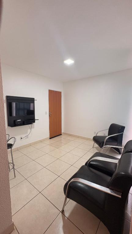 una sala d'attesa con sedie e TV a schermo piatto di Apartamento a Rio Verde