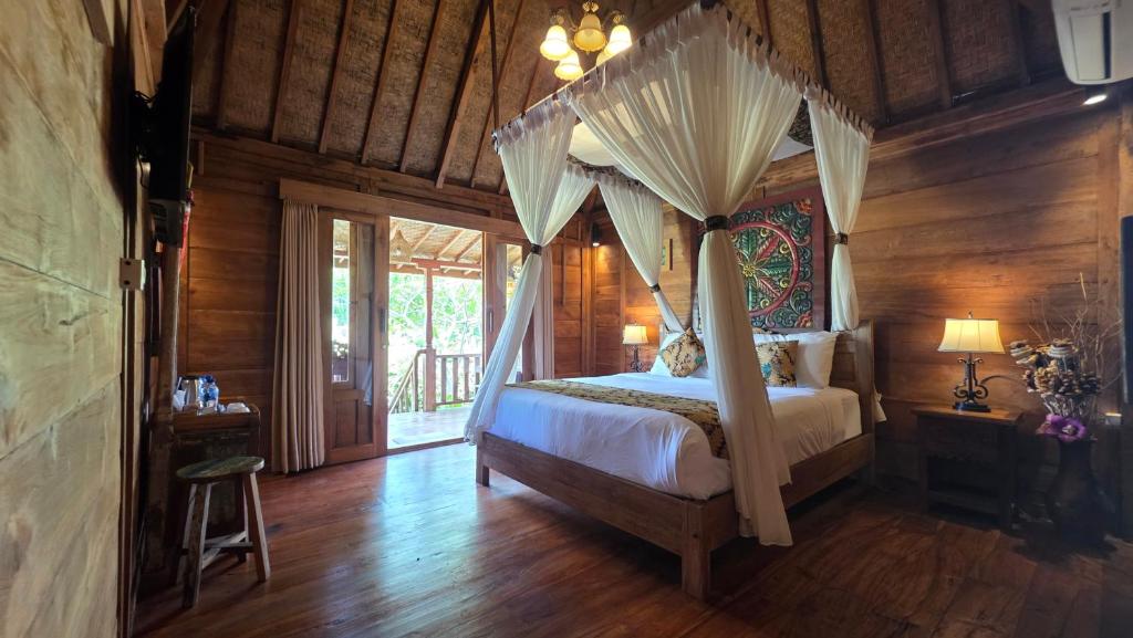 una camera con letto a baldacchino in una stanza con pareti in legno di Sirya Farm House a Meliling