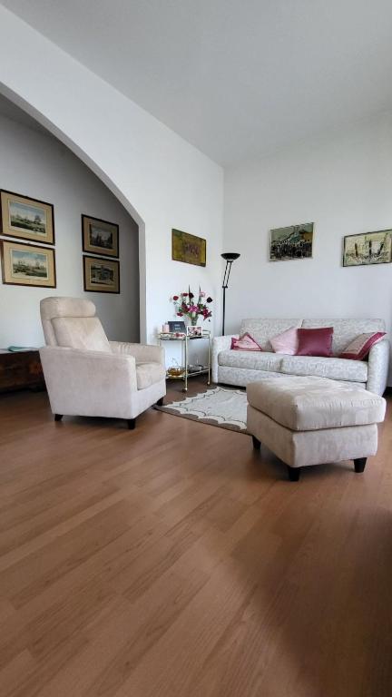 a living room with two white couches and a table at Appartamento il roseto Gubbio in Gubbio