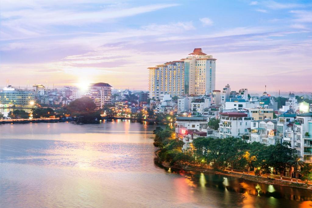 Blick auf eine Stadt mit Fluss und Gebäuden in der Unterkunft Pan Pacific Hanoi in Hanoi