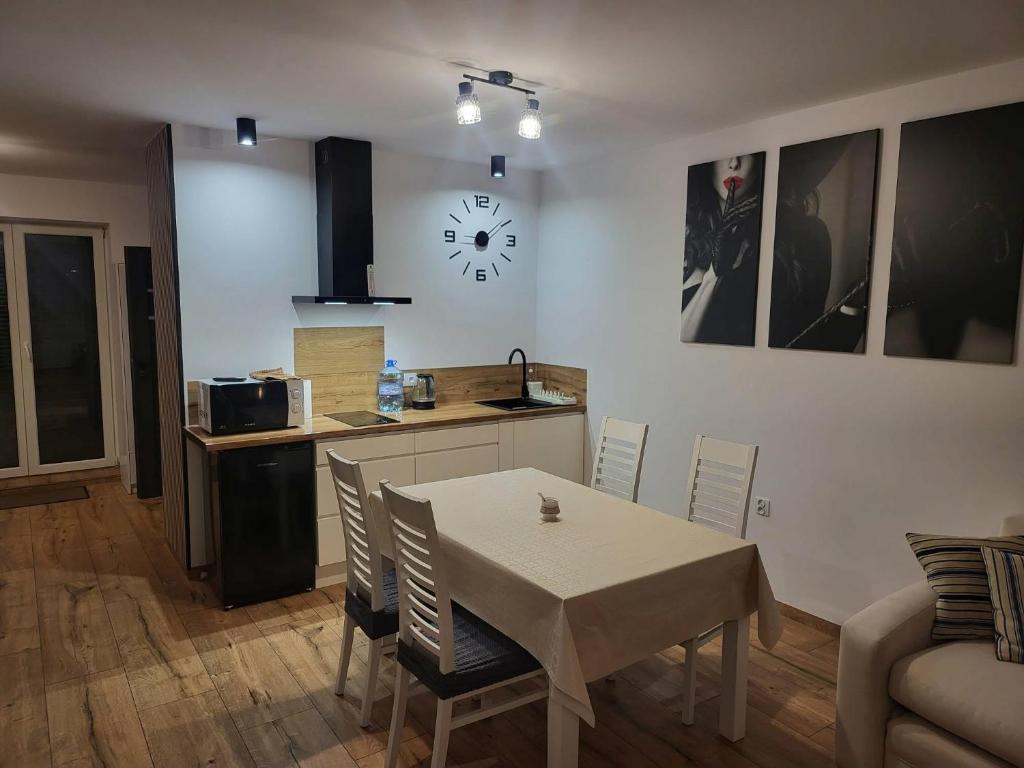a kitchen and a dining room with a table and chairs at Agrobiskupin Kaczmarek in Gąsawa
