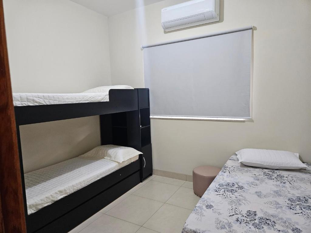 a room with two bunk beds and a window at Aconchego e paz in Rondonópolis