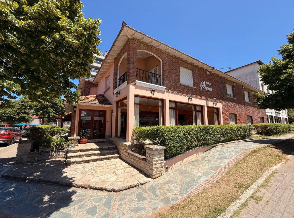 a brick building with a staircase in front of it at Hotel Siena Pinamar in Pinamar