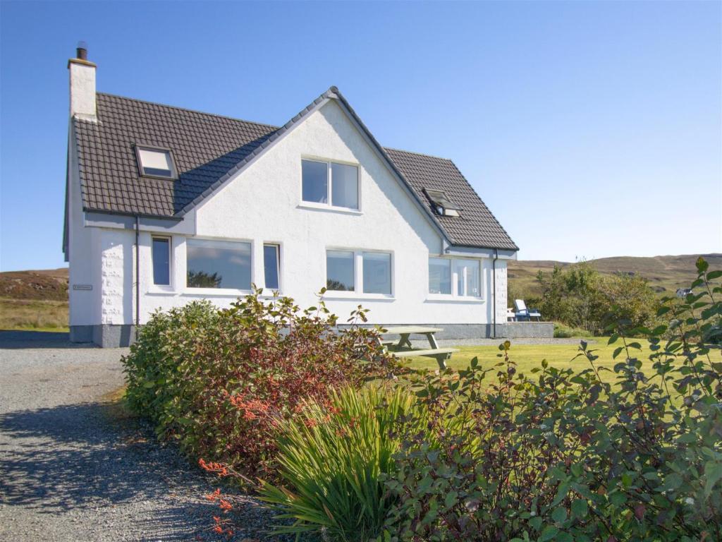 a white house with a black roof at Dalriada in Portree