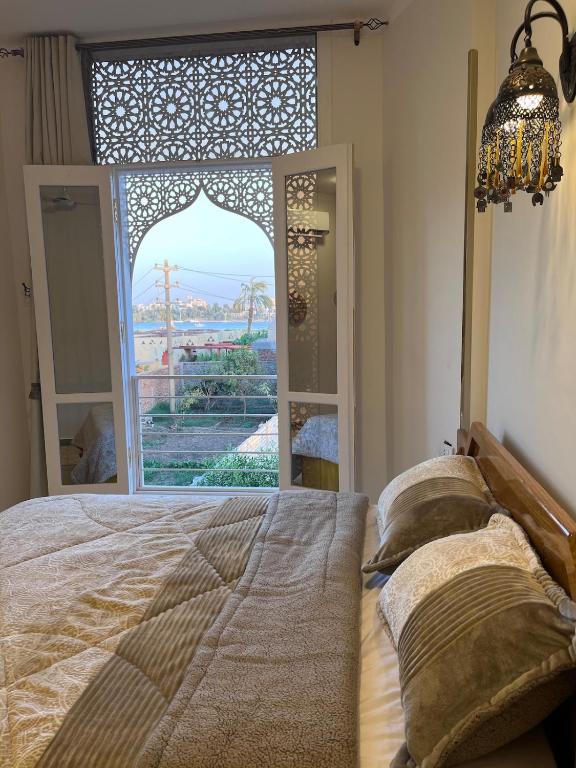 a bedroom with a bed and a large window at Nile view retreat I in Luxor