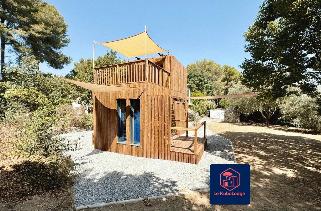 a wooden building with a roof on top of it at Le KuboLodge - Tiny House premium in Jacou