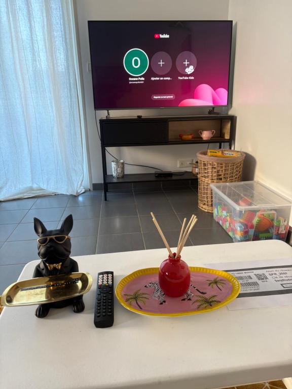 een speelgoedkat die op een tafel zit met een afstandsbediening bij Maison entière avec jardin , Proche Bordeaux, Rocade et Arkéa Arena in Bouliac