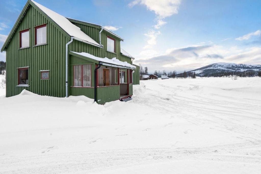 a green house in the snow with snow at Nordnorge Self-Check-In in Majavatn
