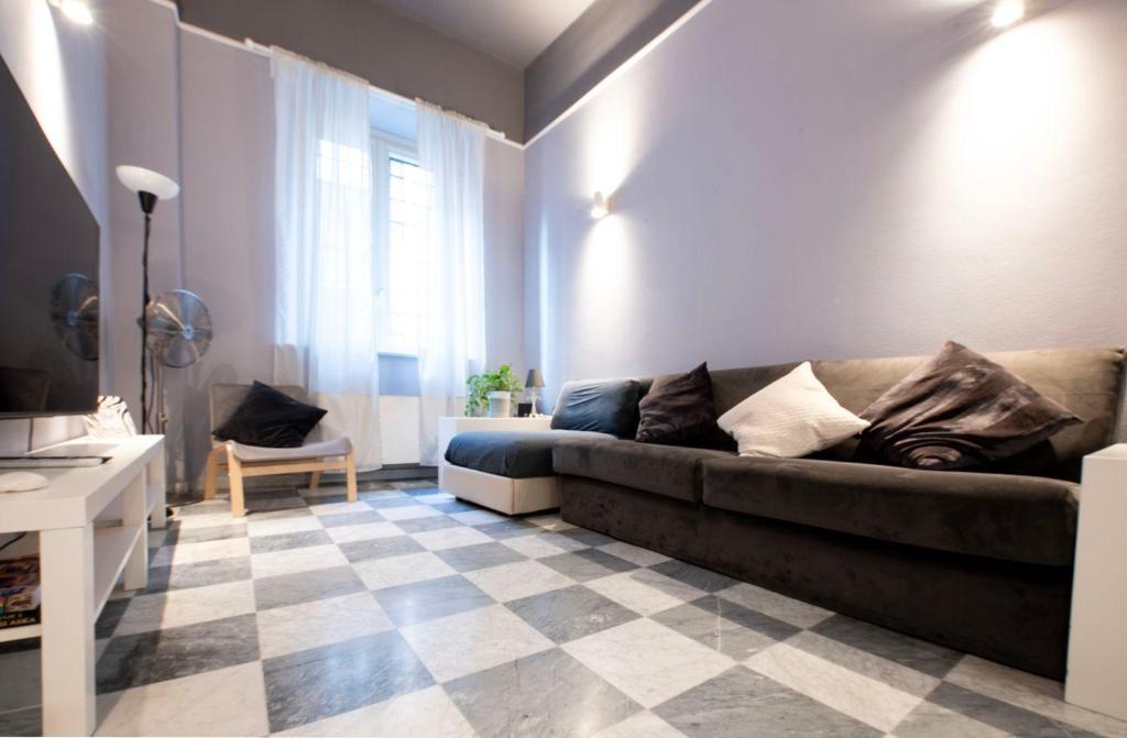 een woonkamer met een bank en een geruite vloer bij Cristina e Elena Suite in Pisa