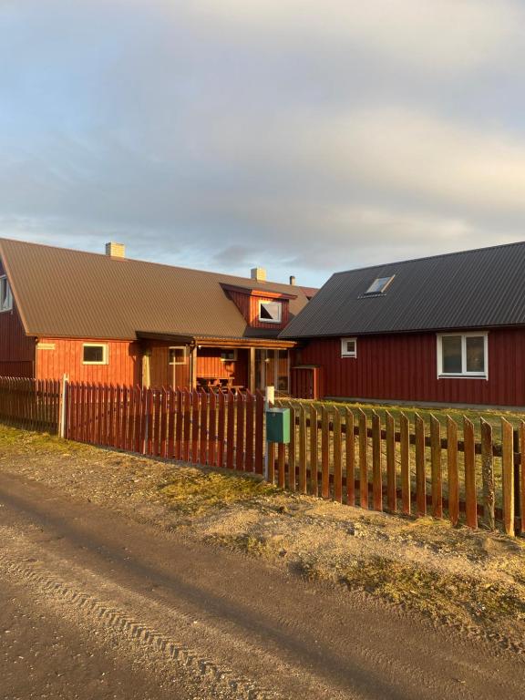 a red barn with a fence next to a house at Vesilinnu 2 in Aabla